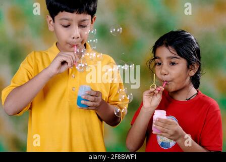 Mumbai, Maharashtra, Indien, Asien, 05. August, 2006 - Süßer kleiner indischer Bruder und Schwester genießen es, wasserblasen zu spielen Stockfoto