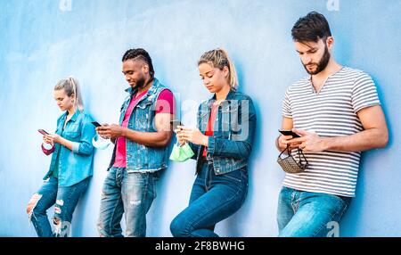 Multirassische Menschen tragen eine Maske mit offenem Gesicht und nutzen die Tracking-App mit Mobile Smartphones - Junge Freunde aus dem Milenial, die sich Inhalte ansehen Soziale Medien Stockfoto