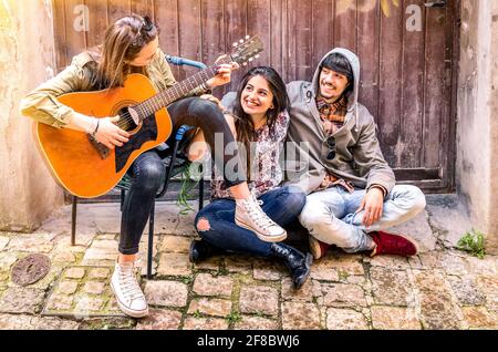 Freunde, die Spaß haben, Gitarre im Freien zu spielen Stockfoto