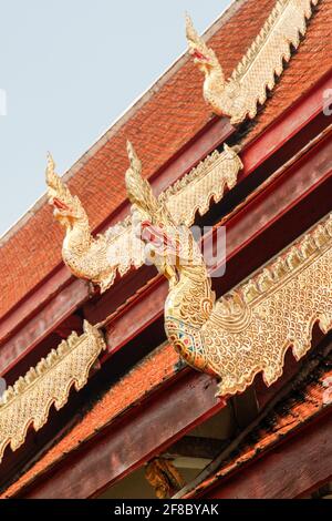 Detail eines geschnitzten Drachen oder einer Schlange auf dem Dach eines traditionellen thailändischen Tempels in Chiang Mai, Thailand Stockfoto