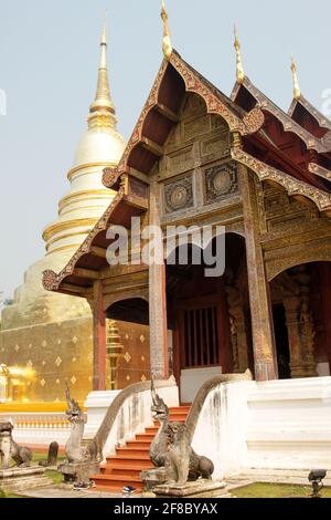 Traditioneller roter Thai-Tempel mit Goldturm oder Stupa im Hintergrund in Chiang Mai, Thailand Stockfoto