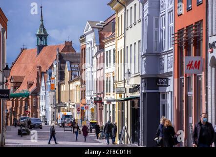 Wismar, Deutschland. April 2021. Nur wenige Passanten sind auf einer der Haupteinkaufsstraßen der Hansestadt unterwegs. Nach wochenlangem Ringen soll die Sperre verschärft werden, Restaurants und Geschäfte bleiben geschlossen. Die Bundesregierung will die dritte Corona-Welle mit einheitlichen Regelungen durchbrechen. Quelle: Jens Büttner/dpa-Zentralbild/dpa/Alamy Live News Stockfoto