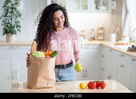 Happy Young Hausfrau Auspacken Lebensmittel Zu Hause Nach Dem Einkaufen Stockfoto