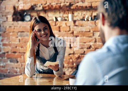 Der Kellner nimmt die Bestellung vom Kundenkommunikationsexperten an Lifestyle Stockfoto