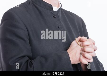 Die Hände des katholischen Priesters halten den Rosenkranz Stockfoto