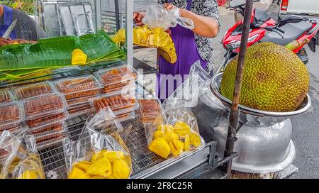 Lebensmittel und Früchte wie Jackfrucht kaufen an einem Street Food Stand in Bangkok Thailand. Stockfoto