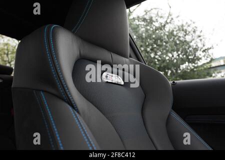 Ein BMW M2 Wettbewerb 2020 mit schwarzem Leder und Blau Akzentnähte mit beleuchtetem M2-Logo in der Mitte von Das Seat BMW M Power Logo Stockfoto