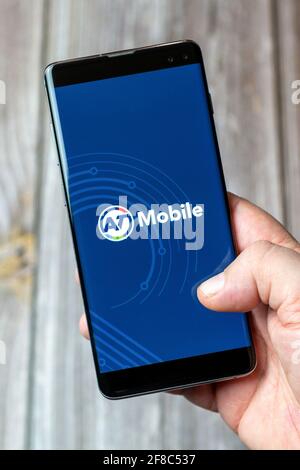 Ein Mobiltelefon oder Mobiltelefon, das in einem gehalten wird Hand mit der AT Mobile App geöffnet auf dem Bildschirm Stockfoto