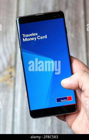 Ein Mobiltelefon oder Mobiltelefon, das in einem gehalten wird Hand mit der Travelex Money Card App geöffnet auf dem Bildschirm Stockfoto