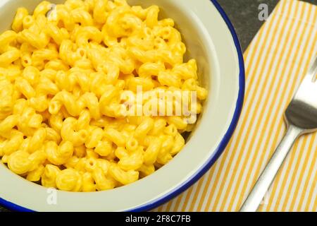 Pasta-Hintergrund. Mac und Käse Pasta auf einem Küchenhintergrund. Italienische Pasta im amerikanischen Stil mit Käse. Hochwertige Fotos Stockfoto