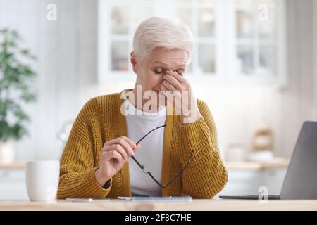 Müde reife Frau Freiberufler arbeiten von zu Hause aus, mit Laptop Stockfoto