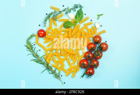 Rohe Fusilli-Pasta mit Tomaten, Kräutern und Basilikum. Italienische Pasta mit Zutaten in den Farben der italienischen Flagge. Hochwertige Fotos Stockfoto