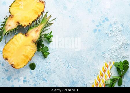 Geschnittene reife Ananas auf hellblauem Stein Hintergrund. Tropische Früchte. Draufsicht. Freier Speicherplatz für Text. Modell. Stockfoto