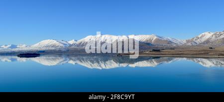 Schneebedeckte Berge spiegeln sich im Lake Tekapo, Neuseeland Stockfoto