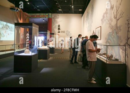 Haikou, Chinas Provinz Hainan. April 2021. Besucher sehen Exponate einer Palastmuseum-Sammlungsausstellung in China (Hainan) Museum des Südchinesischen Meeres in der Stadt Qionghai, südchinesische Provinz Hainan, 13. April 2021. Quelle: Zhang Liyun/Xinhua/Alamy Live News Stockfoto