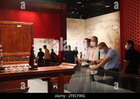 Haikou, Chinas Provinz Hainan. April 2021. Besucher sehen Exponate einer Palastmuseum-Sammlungsausstellung in China (Hainan) Museum des Südchinesischen Meeres in der Stadt Qionghai, südchinesische Provinz Hainan, 13. April 2021. Quelle: Zhang Liyun/Xinhua/Alamy Live News Stockfoto