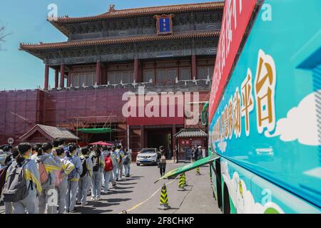 (210413) -- PEKING, 13. April 2021 (Xinhua) -- Touristen kommen an einem mobilen Impffahrzeug COVID-19 vor dem Donghua-Tor des Palastmuseums in Peking, der Hauptstadt von China, vorbei, 13. April 2021. Die mit Impfstationen, medizinischen Kühlschränken und erste-Hilfe-Geräten ausgestatteten Buseinrichtungen wurden in verschiedenen Bezirken von Peking eingeführt, um Zeit zu sparen und die Impfeffizienz zu verbessern. (Xinhua/Zhang Yuwei) Stockfoto