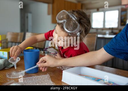 Kinder, die mit Chemie arbeiten, werden am Tisch aufgestellt Stockfoto