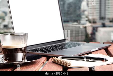 Laptop, Kaffee und Notizblock für Fernarbeiten in Bangkok Stockfoto