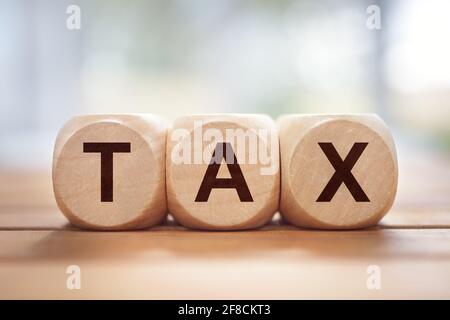 Steuer in Holzblock Buchstaben Hintergrund geschrieben Stockfoto