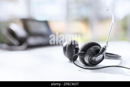 VOIP-Headset Kopfhörer Telefon am Schreibtisch Konzept für Kommunikation, IT-Support, Call Center und Customer Service Help Desk Stockfoto