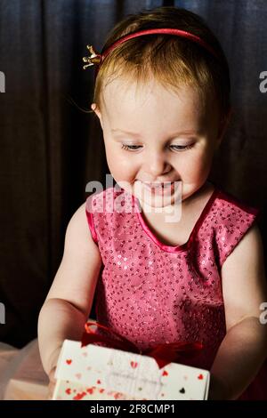 Lächelndes Baby Mädchen, das Geschenk nimmt Stockfoto