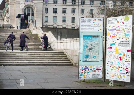 Unbekannte chassidische Männer, die Fahrräder die Treppen auf der Londoner South Bank hinaufschieben Stockfoto