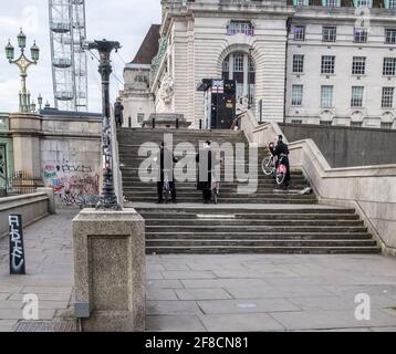 Unbekannte chassidische Männer, die Fahrräder die Treppen auf der Londoner South Bank hinaufschieben Stockfoto