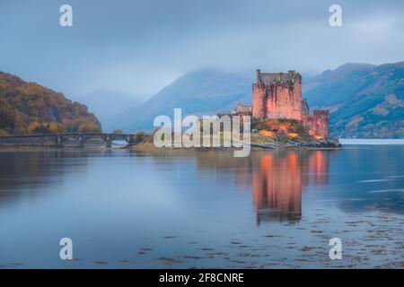 Ruhige, idyllische Nacht im historischen, mittelalterlichen Eilean Donan Castle, beleuchtet mit Spiegelungen auf Loch Duich in den schottischen Highlands, Schottland. Stockfoto