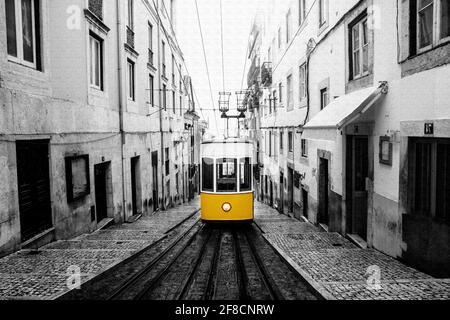 Gelbe Straßenbahn an der alten Straße in Lissabon. Skizzieren Sie ein Schwarzweißbild. Stockfoto