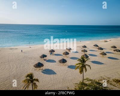 Eagle Beach Aruba, Palmen am Ufer des Eagle Beach in Aruba, Blick auf einen Strand mit Palmen und Sonnenschirmen Stockfoto