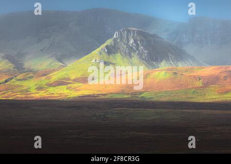 Idyllische und farbenfrohe Landschaft von Staffin mit dramatischem goldenem Licht und Shodow über den Cleat am Quiraing auf dem Trotternish Ridge, Isle Stockfoto