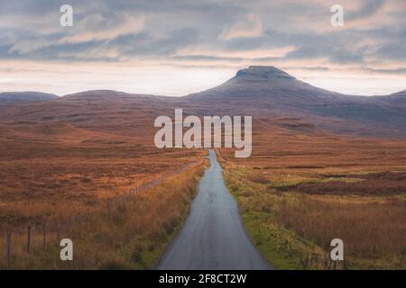 Geradeaus Blick auf die leere Landstraße in der ländlichen Landschaft der schottischen Highlands bei Lonmore auf der Isle of Skye, Schottland. Stockfoto