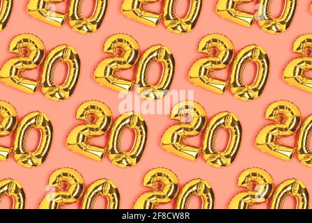 Zahlen 20 goldene Luftballons Muster. Layout der Feierlichkeiten zum 20-jährigen Jubiläum auf einem korallenen Hintergrund. Stockfoto