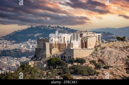 Athen, Griechenland. Akropolis propylaea Tor und Denkmal Agrippa Blick vom Philopappos Hill. Wolkiger, farbenprächtiger Himmel bei der Sonne Stockfoto