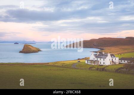 Idyllischer Blick auf die Küste bei Sonnenuntergang oder Sonnenaufgang auf ein ländliches Landhaus in Dultulm an der Küste der Isle of Skye in den schottischen Highlands. Stockfoto