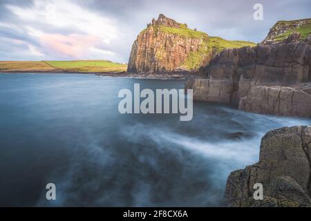 Dramatische Seestücke und Landschaft bei Sonnenuntergang oder Sonnenaufgang der Historische Burgruinen von Dultulm Castle auf der Isle of Skye Coast im schottischen Hochland Stockfoto