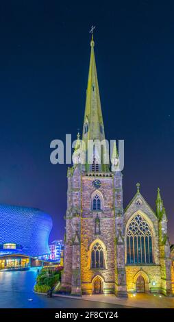 Nachtansicht der Kirche Saint Martin umgeben von Bullring Einkaufszentrum in Birmingham, England Stockfoto