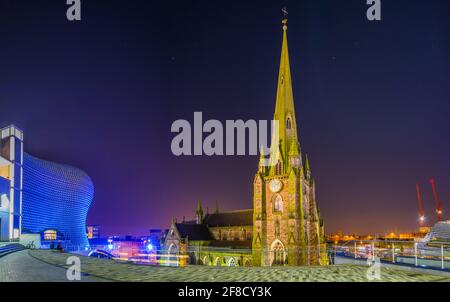 Nachtansicht der Kirche Saint Martin umgeben von Bullring Einkaufszentrum in Birmingham, England Stockfoto