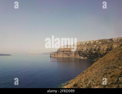 Santorini, Griechenland. Rote vulkanische Inselhügel oder Berge am Strand, einer der schönsten und berühmtesten Strände der Insel Thira, Ägäis, Cycl Stockfoto