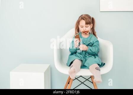Liebenswert Baby Mädchen mit Gesicht in Schokolade bedeckt Stockfoto