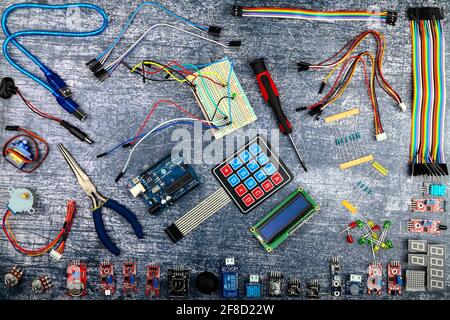 Arduino uno und elektronische Komponenten flach auf einem blauen rustikalen Hintergrund Stockfoto