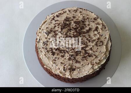 Schokoladenkuchen mit Vanillebutter-Pudereis gemischt mit Schokolade als Belag. Aufgenommen auf weißem Hintergrund. Stockfoto