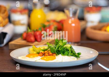 Frühstück mit Eiern, Orangensaft, Croissants, Erdbeeren und ausgewogener Ernährung Stockfoto
