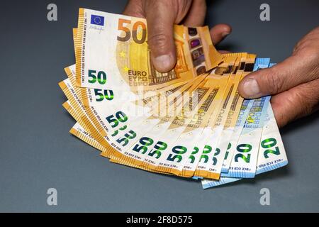 Serie von Banknoten, die in einer fächerförmigen Form auf dem Tisch angeordnet sind. Bargeld, 50 Euro Scheine und 20 Euro Scheine. Stockfoto