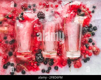 Gläser und gefrorene Beeren. Nahaufnahme, Blick von oben. Schmackhaftes und gesundes Esskonzept Stockfoto