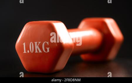 Eine Kilogramm rosa Kurzhantel auf schwarzem Hintergrund Stockfoto