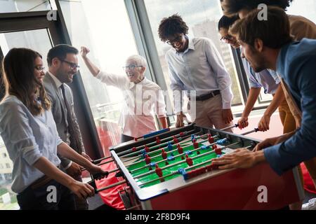 Business Leute, die große Zeit zusammen. Kollegen spielen Tischfußball in modernen Büro Stockfoto