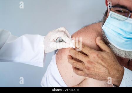 Älterer Mann mit Gesichtsmaske, der kürzlich mit dem Covid-19 geimpft wurde Impfstoff Stockfoto