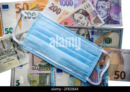 Verschiedene Banknoten Geld auf dem Tisch mit Schutzmedizin chirurgische Maske über Pandemie und epidemischen Einfluss auf die Wirtschaft und Rezessionskonzept Stockfoto